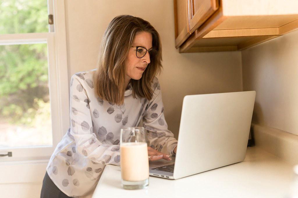 A photograph of a successful freelancer working on their laptop, surrounded by tools of their trade. The freelancer appears confident, focused, and in control of their career.